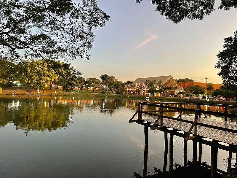 Nossa Prainha, lago com praia artificial cercado de árvores, em Holambra — City Tour CHM Transportes