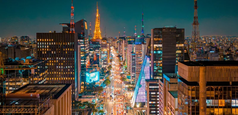 Avenida Paulista à noite, vista do alto com a Torre iluminada, em São Paulo — City Tour CHM Transportes